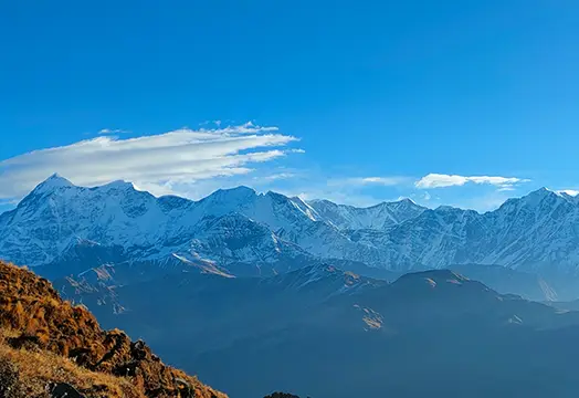 Group of trekkers sitting around a camping table inside a white tent